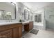 Bathroom with dual sinks, wood cabinets, and a luxurious soaking tub at 1333 E Bermuda Bay Ct, Gilbert, AZ 85234