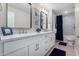 Bathroom with double vanity, framed mirrors, white cabinetry and drawers, with a tub and shower behind a curtain at 1333 E Bermuda Bay Ct, Gilbert, AZ 85234