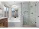 Contemporary bathroom featuring a glass enclosed shower, a soaking tub, and marble-tiled walls at 1333 E Bermuda Bay Ct, Gilbert, AZ 85234