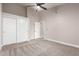 This bedroom features plush carpeting, a modern ceiling fan, and a spacious closet for ample storage at 1333 E Bermuda Bay Ct, Gilbert, AZ 85234