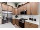 Close up of the kitchen with stainless steel appliances, wood cabinets, and white marble countertops at 1333 E Bermuda Bay Ct, Gilbert, AZ 85234