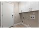 Bright laundry room with white cabinets, laminate floors and washer-dryer hookups ready for customization at 1333 E Bermuda Bay Ct, Gilbert, AZ 85234
