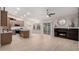Bright, open living space with a fireplace, a ceiling fan, tile floors, and kitchen in background at 1333 E Bermuda Bay Ct, Gilbert, AZ 85234