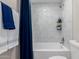 Shower and tub with white and light green tile walls, small corner shelving and blue shower curtain at 1333 E Bermuda Bay Ct, Gilbert, AZ 85234