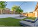 Beautiful backyard with manicured lawn, desert landscaping, string lights, and outdoor furniture at 13720 W Amberwing St, Peoria, AZ 85383