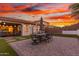 Inviting backyard features a stylish patio with outdoor dining set, artificial grass, and ambient string lights at 13720 W Amberwing St, Peoria, AZ 85383