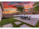 Lush backyard with artificial grass, patio with dining set, lounge chairs, and ambient string lighting at 13720 W Amberwing St, Peoria, AZ 85383