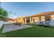 Spacious backyard with a dining set, patio, artificial grass, lounge chairs and string lights for relaxing evenings at 13720 W Amberwing St, Peoria, AZ 85383