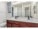 This bright bathroom features dual sinks, dark wood cabinets, and a large mirror with vanity lighting above at 13720 W Amberwing St, Peoria, AZ 85383