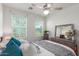 Cozy bedroom featuring a queen bed, ceiling fan, and two windows with natural light at 13720 W Amberwing St, Peoria, AZ 85383