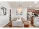 Bright dining area featuring wood-style floors, stylish light fixture, and a view of the modern kitchen at 13720 W Amberwing St, Peoria, AZ 85383