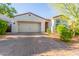 Attractive single-story home showcasing a brick driveway, two-car garage and desert landscaping at 13720 W Amberwing St, Peoria, AZ 85383