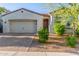 Charming single-story home featuring a brick driveway, two-car garage and desert landscaping at 13720 W Amberwing St, Peoria, AZ 85383