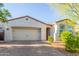 Welcoming single-story home featuring a brick driveway, two-car garage and desert landscaping at 13720 W Amberwing St, Peoria, AZ 85383