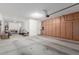 Spacious garage with custom built-in cabinets and ample storage space for vehicles and other items at 13720 W Amberwing St, Peoria, AZ 85383
