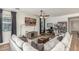 Cozy living room features a sectional sofa, ceiling fan, desk and bookcase at 13720 W Amberwing St, Peoria, AZ 85383