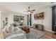 Comfortable living room with a large sectional sofa, ceiling fan, and sliding glass doors at 13720 W Amberwing St, Peoria, AZ 85383