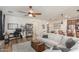 Spacious living room featuring hardwood floors, ceiling fan, a workstation and a large couch at 13720 W Amberwing St, Peoria, AZ 85383
