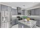 Modern kitchen boasts gray cabinets, stainless steel appliances, granite countertops, and an island at 14870 W Encanto Blvd # 1061, Goodyear, AZ 85395