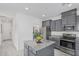 Modern kitchen with gray cabinets, granite countertops, stainless steel appliances, and an island at 14870 W Encanto Blvd # 1061, Goodyear, AZ 85395