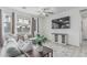 Bright living room with gray sectional, ceiling fan, stylish console and large windows offers cozy relaxation at 14870 W Encanto Blvd # 1061, Goodyear, AZ 85395