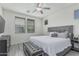 Calm main bedroom with gray upholstered bed, bench, ceiling fan, and a window with blinds at 14870 W Encanto Blvd # 1061, Goodyear, AZ 85395