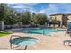 Community pool and hot tub with lounge chairs and manicured landscaping on a clear, sunny day at 14870 W Encanto Blvd # 1061, Goodyear, AZ 85395
