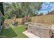 Landscaped backyard with hot tub, artificial turf, and an outdoor seating area at 15815 N 4Th Dr, Phoenix, AZ 85023