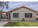 Back exterior featuring a covered patio, two windows, grass lawn and access to outdoor living spaces at 15902 W Hearn Rd, Surprise, AZ 85379