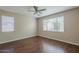 Neutral bedroom featuring wood-look floors, a ceiling fan, and a double-hung window at 15902 W Hearn Rd, Surprise, AZ 85379
