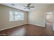 Neutral bedroom with wood-look floors, a ceiling fan, and natural light from the window at 15902 W Hearn Rd, Surprise, AZ 85379