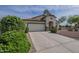 Charming single-story home featuring a stucco facade, tile roof, two-car garage, and desert landscaping at 15902 W Hearn Rd, Surprise, AZ 85379