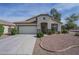 Inviting single-story home showcases a well-manicured lawn, two-car garage, and neutral color palette at 15902 W Hearn Rd, Surprise, AZ 85379