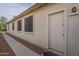 Exterior view featuring neutral stucco siding, multiple windows, and a sidewalk leading to the entrance at 15902 W Hearn Rd, Surprise, AZ 85379
