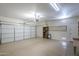 Spacious two car garage featuring light concrete floors, automatic door, and shelving at 15902 W Hearn Rd, Surprise, AZ 85379