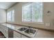 Bright kitchen featuring a stainless steel sink beneath two windows with white blinds at 15902 W Hearn Rd, Surprise, AZ 85379