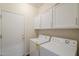 Laundry room featuring a washer, dryer, white cabinets, and a door to the backyard at 15902 W Hearn Rd, Surprise, AZ 85379