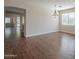 Open-concept living area with wood flooring, neutral walls, and modern lighting at 15902 W Hearn Rd, Surprise, AZ 85379