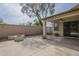 Covered patio area featuring a stone fire pit, privacy wall, and ceiling fan for outdoor enjoyment at 15902 W Hearn Rd, Surprise, AZ 85379