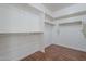 Spacious walk-in closet with built-in shelving and wood-style flooring at 15902 W Hearn Rd, Surprise, AZ 85379