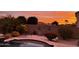 Inviting backyard at sunset featuring a pool, desert landscaping, and cozy seating area at 16280 W Durango St, Goodyear, AZ 85338