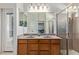 Bright bathroom featuring double sink vanity, large mirror, and a glass enclosed shower offering a functional design at 16280 W Durango St, Goodyear, AZ 85338