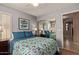 Bright bedroom featuring a queen bed, floral quilt, mirrored closet doors, and modern décor at 16280 W Durango St, Goodyear, AZ 85338