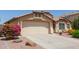 Charming single-story home with a two-car garage, desert landscaping, and a vibrant pink flowering bush at 16280 W Durango St, Goodyear, AZ 85338
