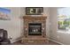 Close-up of a stone fireplace with mantel, flanked by decor with a window to the right offering natural light at 16280 W Durango St, Goodyear, AZ 85338