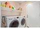 Functional laundry room with washer, dryer, shelving and convenient access to an exterior door at 16280 W Durango St, Goodyear, AZ 85338