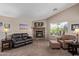 Inviting living room features a stone fireplace, plush seating, and a large window, creating a cozy atmosphere at 16280 W Durango St, Goodyear, AZ 85338