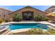 Stunning backyard featuring a sparkling pool with steps, palm trees and a covered patio, creating a serene oasis at 16280 W Durango St, Goodyear, AZ 85338