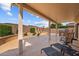 Covered patio seating area with outdoor kitchen overlooking a spacious backyard and desert landscaping at 16444 W Chuparosa Ln, Surprise, AZ 85387