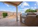 Outdoor kitchen and covered patio in a private backyard with desert landscaping at 16444 W Chuparosa Ln, Surprise, AZ 85387